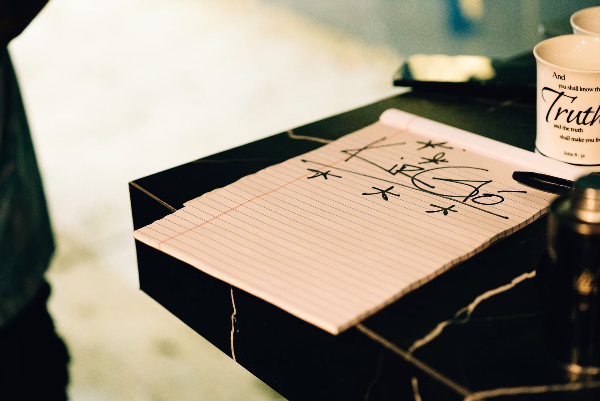 Retna's handwritten Kirgo lettering sketch beside a Truth mug on the studio table