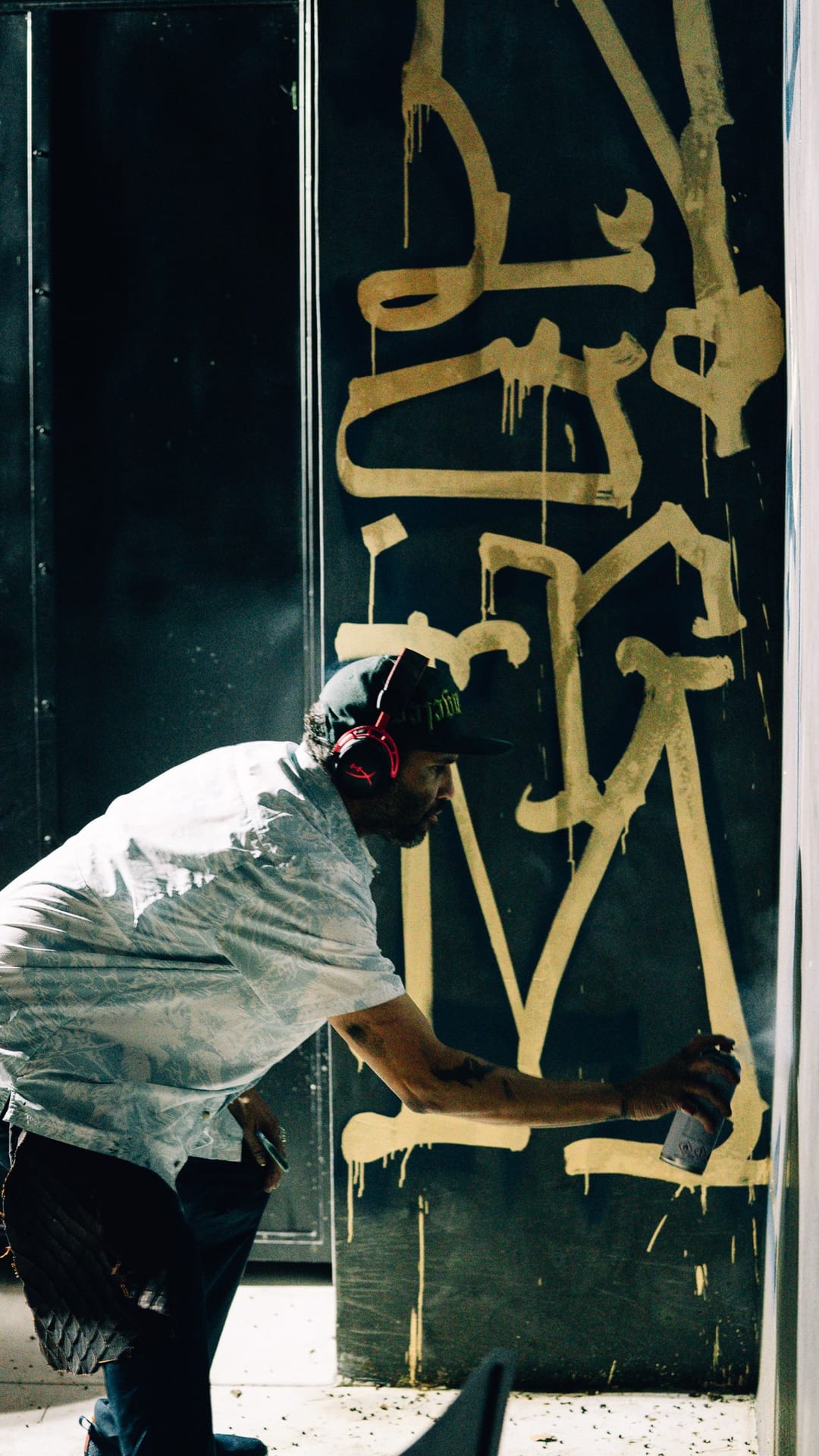 Retna spray painting his signature gold calligraphy live for HYPR and Kirgo