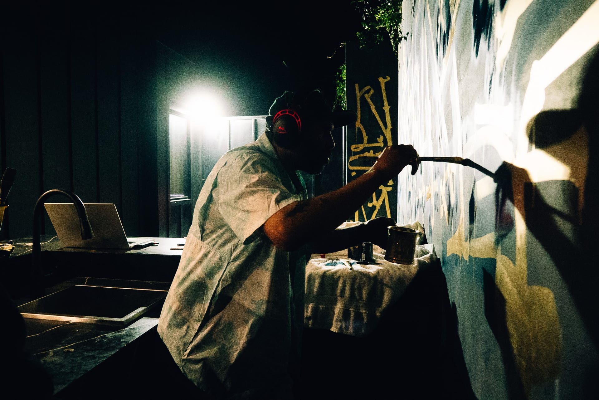 Retna painting his calligraphy mural under studio lighting, captured by HYPR