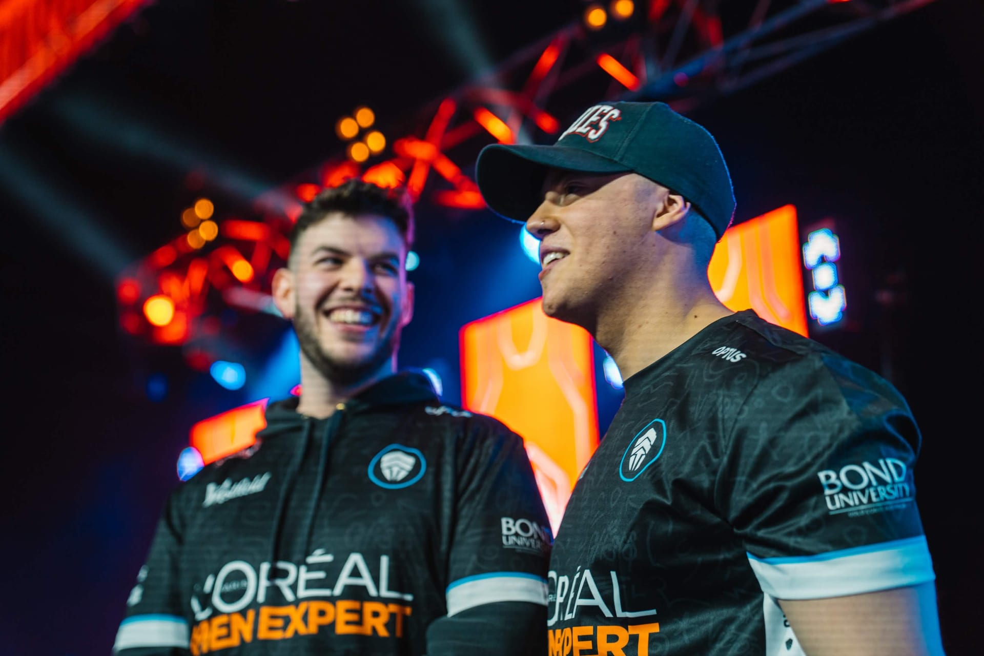 Chiefs Esports Club players sharing a laugh at the LCO event in their L'Oreal and Bond University jerseys
