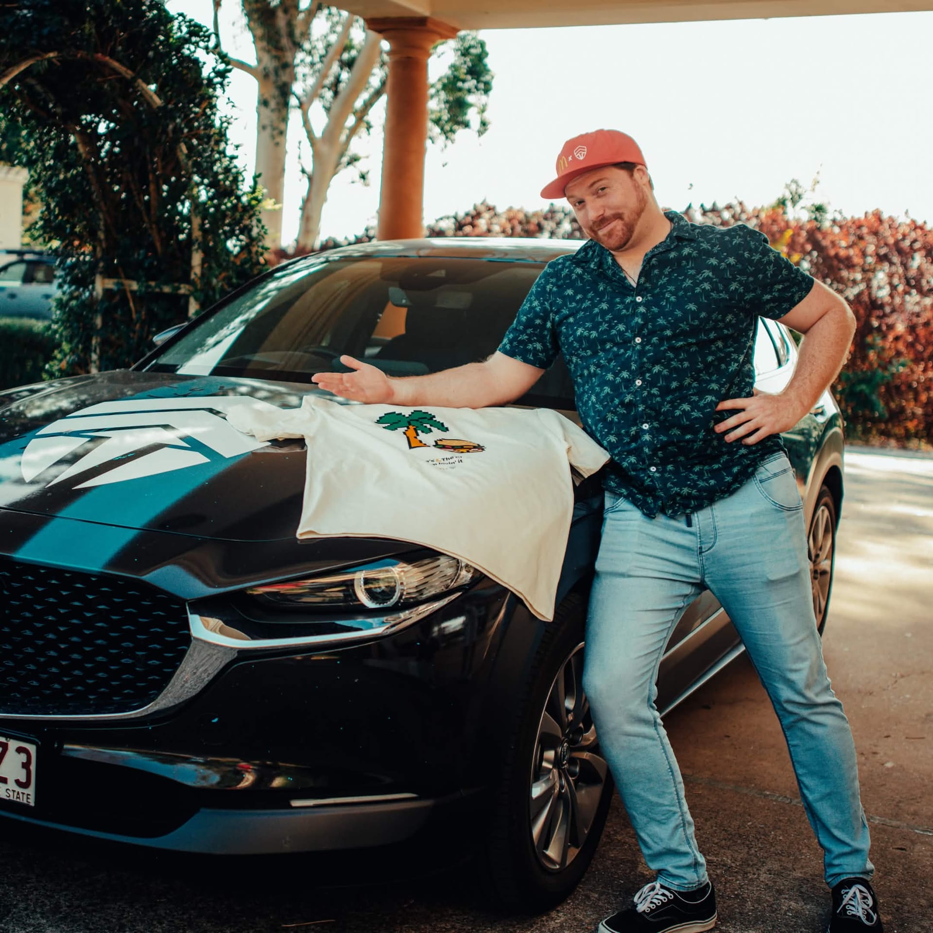 Creator presenting the limited edition McDonald's x Chiefs Summer of Gaming tee on a car bonnet