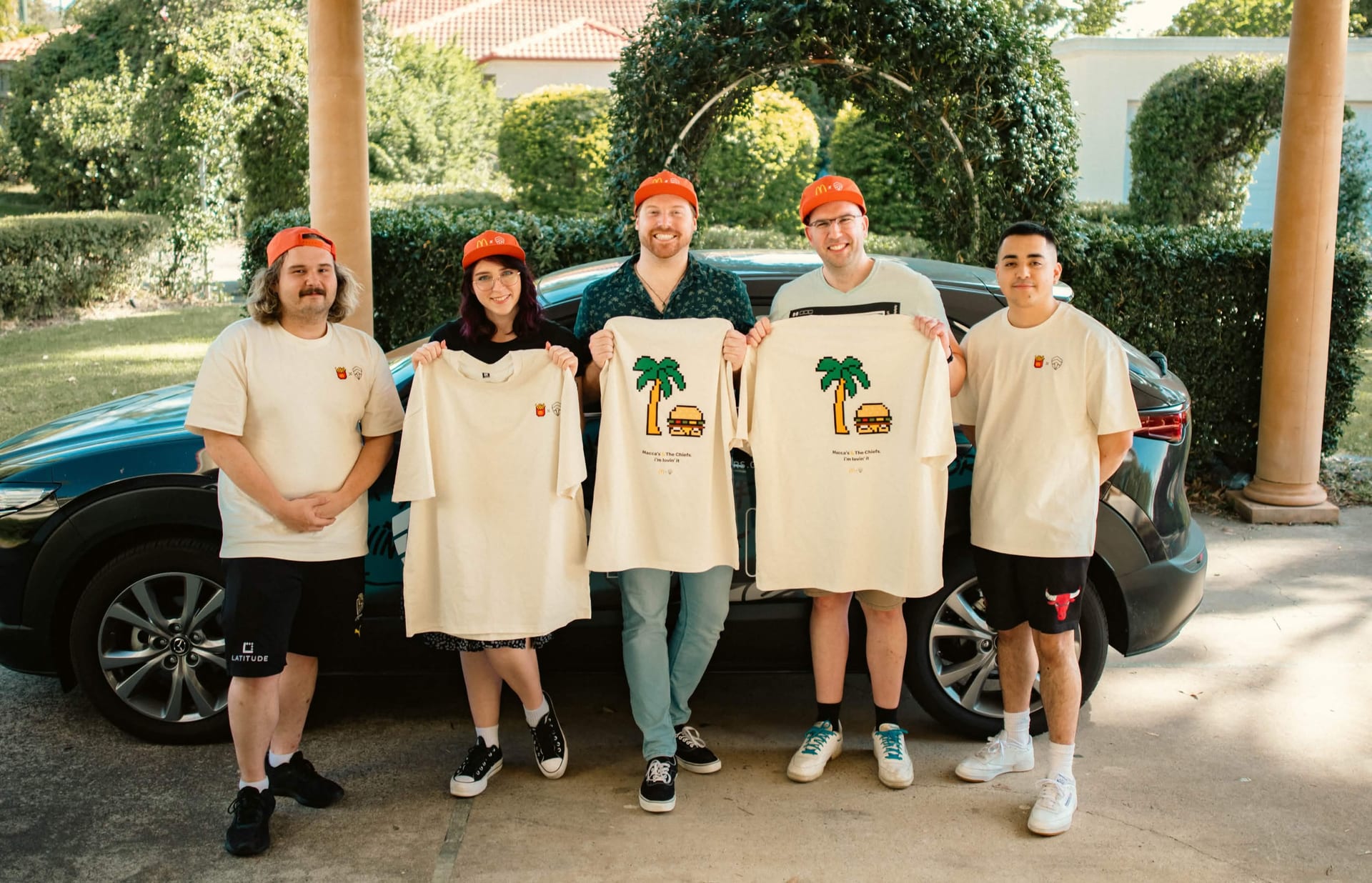 The team holding the pixel palm and burger Summer of Gaming tees at the McDonald's x Chiefs activation
