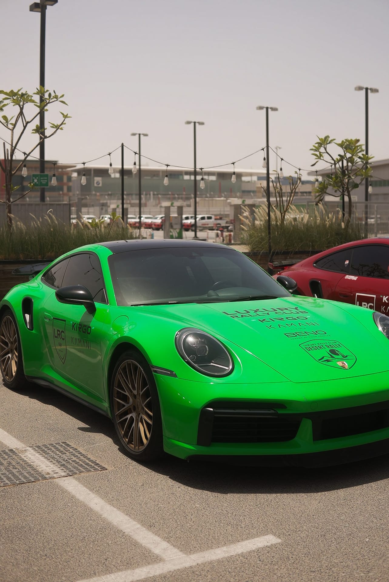 Green Porsche 911 in Luxury Rally Club livery at the UAE Desert Rally